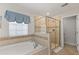 Elegant bathroom with tub, separate glass shower, and decorative tile at 9023 Shadow Mountain St, Davenport, FL 33896