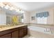 Luxurious bathroom features double sinks, a soaking tub, and decorative tile accents at 9023 Shadow Mountain St, Davenport, FL 33896