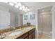Elegant bathroom features a double sink vanity with granite countertop and a glass-enclosed shower at 9023 Shadow Mountain St, Davenport, FL 33896