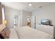 Bright bedroom with a queen bed, dresser with television, and multiple entrances at 9023 Shadow Mountain St, Davenport, FL 33896