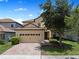 Charming two-story home featuring a tile roof, brick driveway, and well-maintained landscaping at 9023 Shadow Mountain St, Davenport, FL 33896