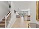 Bright hallway featuring neutral tile flooring, white walls, staircase and an open view to the kitchen and living areas at 9023 Shadow Mountain St, Davenport, FL 33896