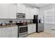 Bright kitchen features white cabinets, stainless steel appliances, and granite countertops with tile flooring at 9023 Shadow Mountain St, Davenport, FL 33896