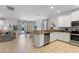 This open concept kitchen with stainless steel appliances has an eat-in kitchen, a dining space and an adjacent living area at 9023 Shadow Mountain St, Davenport, FL 33896