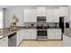 This bright kitchen features white cabinets, stainless steel appliances, and granite countertops with tile flooring at 9023 Shadow Mountain St, Davenport, FL 33896