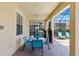 Covered brick lanai includes an outdoor dining table with a grill, ceiling fans, and lounging area at 9023 Shadow Mountain St, Davenport, FL 33896