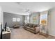 Cozy living room with a gray sofa, media center, and lots of natural light at 9023 Shadow Mountain St, Davenport, FL 33896
