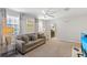 Bright living room featuring a comfortable gray sofa and large windows at 9023 Shadow Mountain St, Davenport, FL 33896
