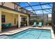 Screened lanai with large pool, hot tub, covered patio, dining area, and lounge chairs create outdoor oasis at 9023 Shadow Mountain St, Davenport, FL 33896