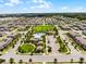 Expansive aerial view showcasing a well-planned community with a central pool, playground, and green spaces at 9128 Sonoma Coast Dr, Winter Garden, FL 34787