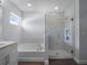 Bathroom showcases a soaking tub, a walk-in shower with glass doors, and wood look tile floors at 9128 Sonoma Coast Dr, Winter Garden, FL 34787