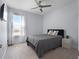 Cozy bedroom with a ceiling fan, plush carpeting, and a large window for natural light at 9128 Sonoma Coast Dr, Winter Garden, FL 34787