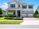 Welcoming two-story home with lush landscaping, a two-car garage, and a brick-paved driveway at 9128 Sonoma Coast Dr, Winter Garden, FL 34787