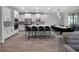 Modern kitchen featuring white cabinets, an island with seating, and an adjacent dining area with stylish black chairs at 9128 Sonoma Coast Dr, Winter Garden, FL 34787