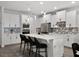 Stylish kitchen boasts white cabinets, stainless appliances, tiled backsplash, and an island with breakfast bar seating at 9128 Sonoma Coast Dr, Winter Garden, FL 34787