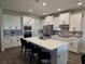 Bright kitchen featuring white cabinetry, an island with seating, stainless steel appliances, and modern lighting at 9128 Sonoma Coast Dr, Winter Garden, FL 34787