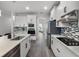 Modern kitchen featuring white cabinetry, stainless steel appliances, mosaic backsplash, and wood-look tile flooring at 9128 Sonoma Coast Dr, Winter Garden, FL 34787