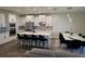 Modern kitchen with white cabinets, stainless steel appliances, an island, and adjacent dining area at 9128 Sonoma Coast Dr, Winter Garden, FL 34787