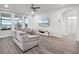 Bright and airy living room with large windows, wood flooring, and comfortable seating, perfect for relaxing and entertaining at 9128 Sonoma Coast Dr, Winter Garden, FL 34787