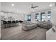 Open concept living and dining area with modern kitchen, sleek furniture, and bright windows leading to outdoor spaces at 9128 Sonoma Coast Dr, Winter Garden, FL 34787