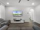 Bright living room with wood floors, media center, and access to a bathroom through a stylish arched doorway at 9128 Sonoma Coast Dr, Winter Garden, FL 34787