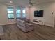 Cozy living room with wood-look tile flooring, comfortable seating, and a large window for natural light at 9128 Sonoma Coast Dr, Winter Garden, FL 34787