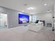 Spacious living room with a large projector screen, comfortable seating, and access to an en suite bathroom at 9128 Sonoma Coast Dr, Winter Garden, FL 34787