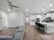 Open-concept living area features a sleek gray sofa, flowing into a kitchen with a modern island and bar stools at 9128 Sonoma Coast Dr, Winter Garden, FL 34787