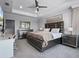Cozy main bedroom featuring soft carpet, tray ceilings, a large bed, and an en suite bath at 9128 Sonoma Coast Dr, Winter Garden, FL 34787