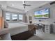 Bright main bedroom features large windows, tray ceilings, plush carpet, a desk, and a large television at 9128 Sonoma Coast Dr, Winter Garden, FL 34787
