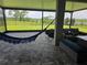 Relaxing screened-in patio with comfortable seating, a hammock, and scenic views of the backyard and lake at 9128 Sonoma Coast Dr, Winter Garden, FL 34787
