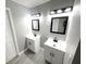 Bathroom with dual vanities, modern fixtures and framed mirrors at 926 Freshmeadow Ct, Apopka, FL 32703