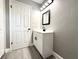 Bathroom featuring modern vanity with dark fixtures and updated lighting, along with wood-look flooring at 926 Freshmeadow Ct, Apopka, FL 32703