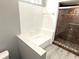 Bright bathroom features white tiled walls, a shower with glass doors, and wood-look flooring at 926 Freshmeadow Ct, Apopka, FL 32703