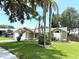 Manicured lawn, colorful foliage, and palm trees accent this home's exterior at 926 Freshmeadow Ct, Apopka, FL 32703
