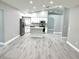 Spacious open kitchen with gray wood floors, granite countertops, and stainless steel appliances at 926 Freshmeadow Ct, Apopka, FL 32703