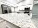 Modern kitchen island with white cabinets and sleek gray, black and white granite countertop at 926 Freshmeadow Ct, Apopka, FL 32703