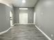 Living room featuring modern gray walls, wood-look flooring, an arched doorway, and natural light at 926 Freshmeadow Ct, Apopka, FL 32703