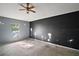 A bedroom with a ceiling fan, window, and black accent wall at 979 Mayfair St, Eustis, FL 32726