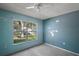 A bedroom with a large window and blue walls at 979 Mayfair St, Eustis, FL 32726