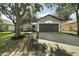 View of home featuring a well-manicured lawn and neutral colored exterior, including a gray garage door at 979 Mayfair St, Eustis, FL 32726