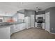 Kitchen featuring tile floors, white cabinets, stainless steel appliances, with open access to the living spaces at 979 Mayfair St, Eustis, FL 32726