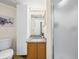 Well-lit bathroom with vanity, granite countertop, toilet, and shower at 1111 Liberty Hall Dr, Kissimmee, FL 34746