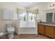 Well-lit bathroom with corner tub, granite countertop vanity, and wood-look vinyl flooring at 1111 Liberty Hall Dr, Kissimmee, FL 34746