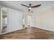 Bright bedroom featuring wood floors, ceiling fan and storage closet with mirrored doors at 1111 Liberty Hall Dr, Kissimmee, FL 34746
