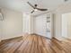 Bright bedroom featuring wood floors, ceiling fan and storage closet with mirrored doors at 1111 Liberty Hall Dr, Kissimmee, FL 34746