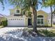 Charming two-story home with a manicured lawn, two-car garage, and classic architectural details at 1111 Liberty Hall Dr, Kissimmee, FL 34746