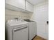 Bright laundry room equipped with a washer, dryer, and overhead cabinets at 1111 Liberty Hall Dr, Kissimmee, FL 34746
