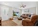 Cozy living room with a stone fireplace, ceiling fan, and comfortable brown sofas at 1166 Mapimi Ct, Winter Springs, FL 32708