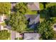 An aerial view shows a well-maintained home with a dark roof, green lawn, and mature trees at 1173 Valley Creek Run, Winter Park, FL 32792
